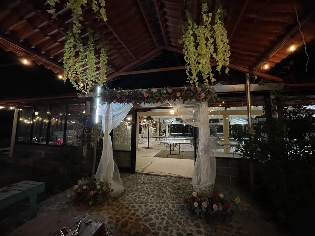 Arco de flores en la entrada del salón, de noche