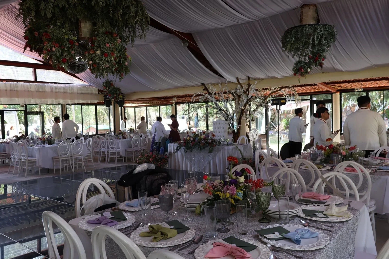 Salón vestido para el banquete con mantelería y centros de mesa