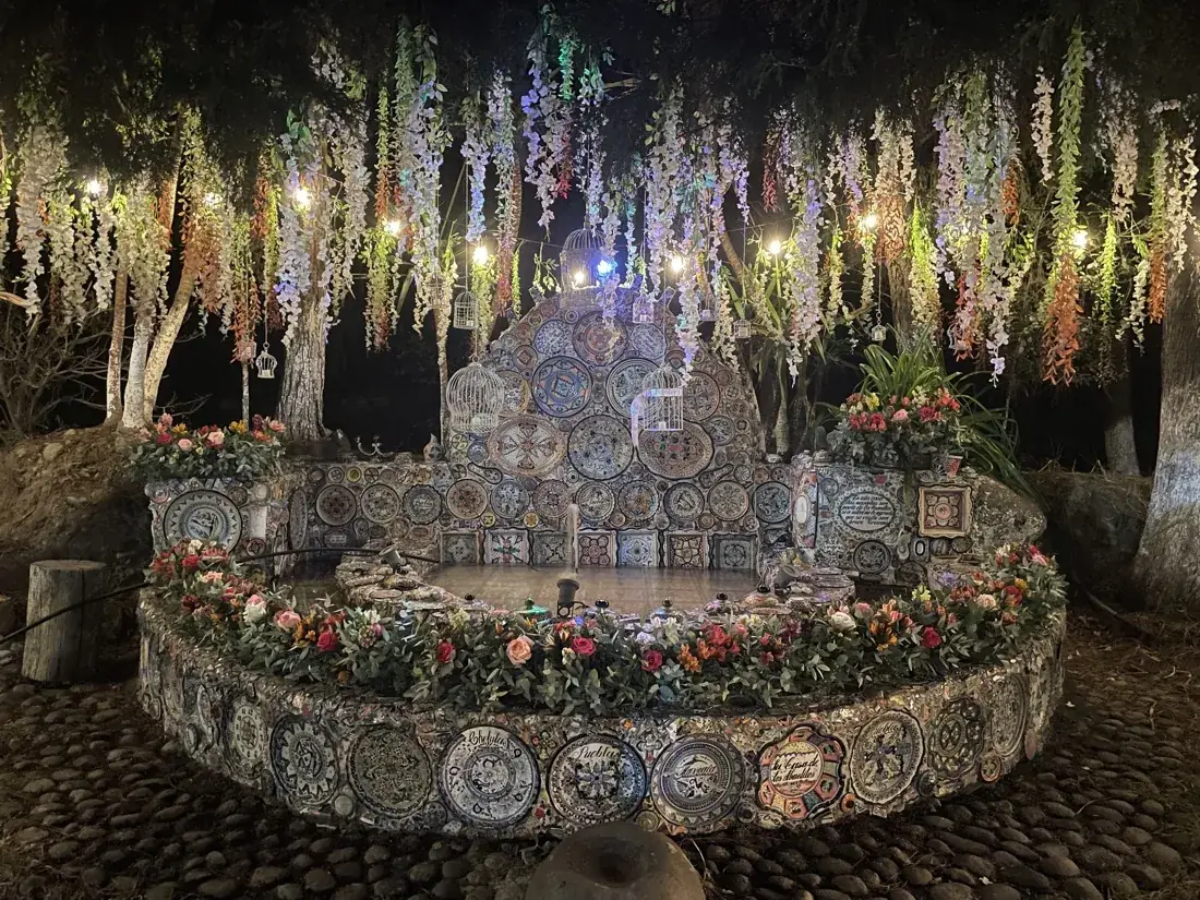 Fuente de talavera iluminada y decorada con flores para una boda